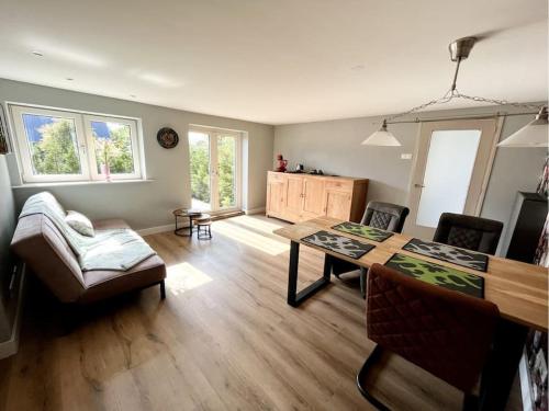 ein Wohnzimmer mit einem Tisch und einem Sofa in der Unterkunft Eigen appartement op boerderij tussen de velden. in Tweede Exloërmond