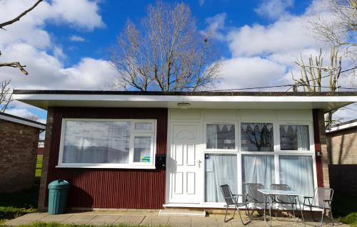 a small house with a table and chairs at 'Sunnyside' Chalet, walk to the beach & close to Norfolk broads - pet friendly! in Great Yarmouth