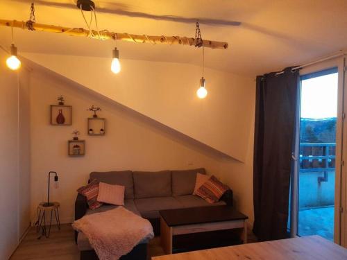 - un salon avec un canapé et une fenêtre dans l'établissement Location appartement à Bonascre, à Ax-les-Thermes