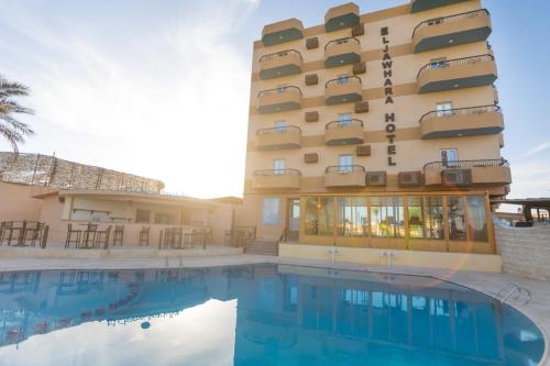 a hotel with a swimming pool in front of a building at Jawhara Inn Hotel - فندق الجوهرة سفاجا in Hurghada