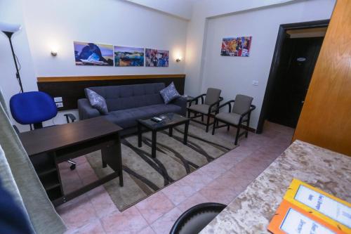 a living room with a couch and a table and chairs at Jawhara Inn Hotel - فندق الجوهرة سفاجا in Hurghada