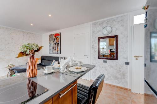 a kitchen with a counter with a sink and a vase of flowers at Beach Apartment Bungamericas - Sea View Playa de las Americas in Playa de las Americas