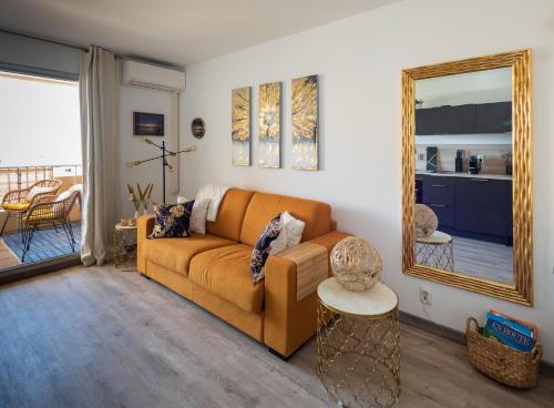 un salon avec un canapé et un miroir dans l'établissement Studio Marina, de Parel aan de Côte d'Azur, à Hyères