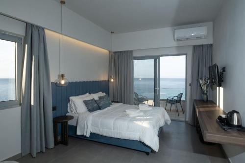 Mochlos Blue في موخلوس: غرفة نوم مع سرير وإطلالة على المحيط