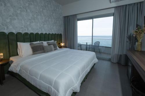a bedroom with a large white bed and a large window at Mochlos Blue in Mochlos
