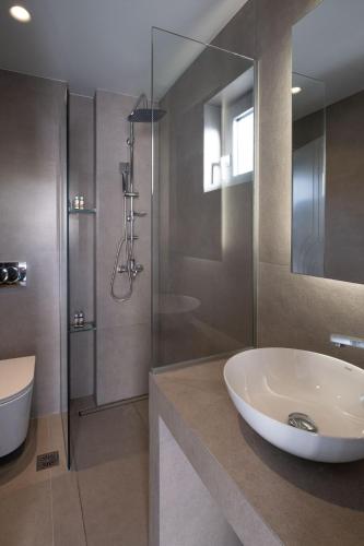 a bathroom with a sink and a glass shower at Mochlos Blue in Mochlos