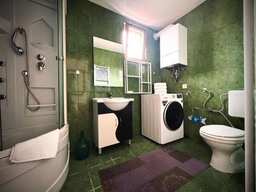 baño verde con lavadora y lavamanos en Apartment Centar, en Sarajevo
