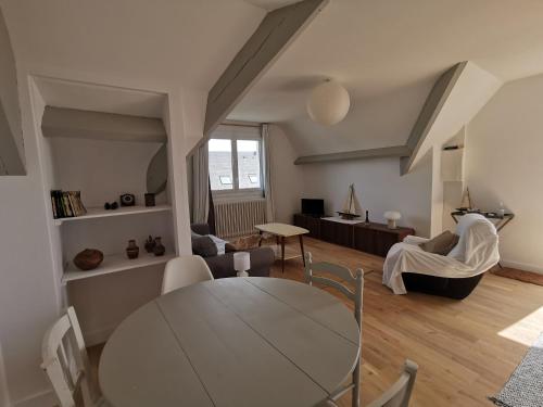 ein Wohnzimmer mit einem Tisch und einem Sofa in der Unterkunft Les Embruns in Bréhal