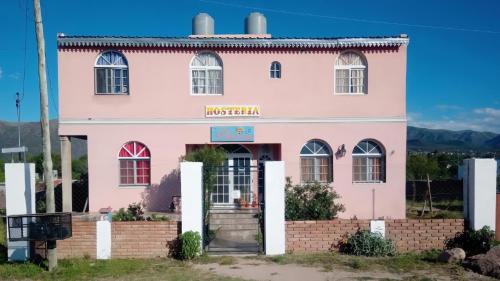 un bâtiment rose avec un panneau indiquant le moroccan dans l'établissement Hosteria Dharma, à Capilla del Monte