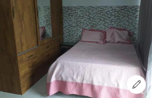 Casa em Camboinhas, Niterói, RJ في نيتيروي: غرفة نوم بسرير كبير مع شراشف وردية