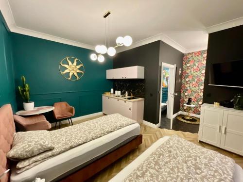 a bedroom with a bed and a table and a kitchen at Apartamenty Green in Stargard