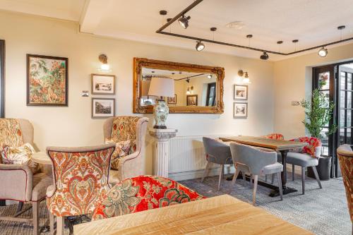 a living room with a table and chairs and a mirror at The Manor Coastal Hotel & Inn, Blakeney - The Coaching Inn Group in Blakeney