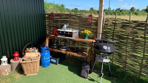 einen Grill auf einem Tisch neben einem Zaun in der Unterkunft Willowdene shepherds hut in Oswestry