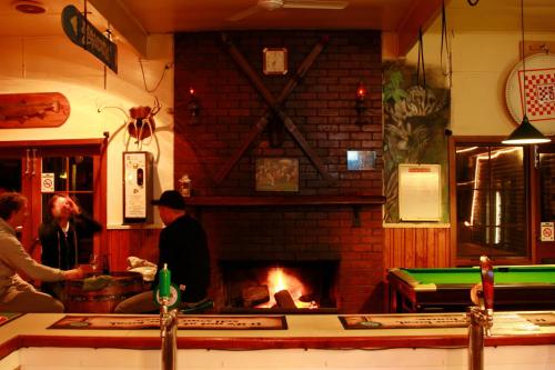 a living room with a fireplace and a fire place at The Harrietville Snowline Hotel in Harrietville