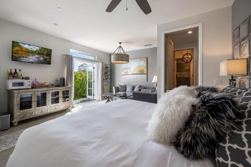 a bedroom with a large white bed and a living room at Domaine Chardonnay in Temecula