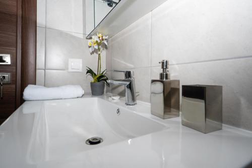 uma casa de banho branca com um lavatório com uma torneira em Maisonette near Heraklion Center Candia Maisonette em Heraclião