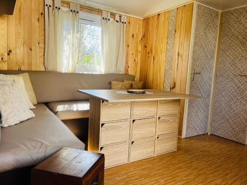 ein Zimmer mit einem Sofa und einem Tisch in einem Zimmer in der Unterkunft Mobil-home COSY clim&tv-3 Chambres in Vic-la-Gardiole
