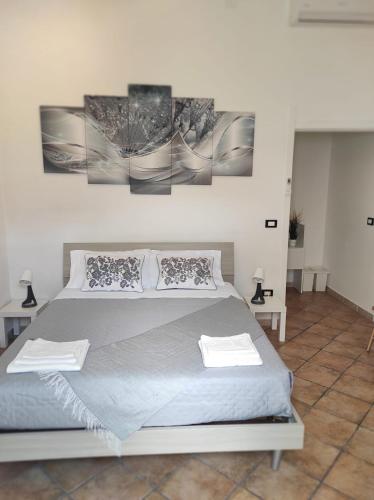 - une chambre avec un lit orné de 3 peintures murales dans l'établissement Affittacamere “La spezia “, à La Spezia
