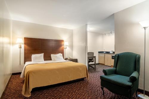 a hotel room with a bed and a chair at Quality Inn Marietta in Marietta