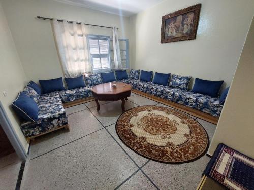 a living room with blue couches and a table at Appartement Hamria Meknes BT in Meknès