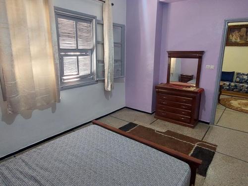 Zimmer mit Spiegel und Kommode in der Unterkunft Appartement Hamria Meknes BT in Meknès