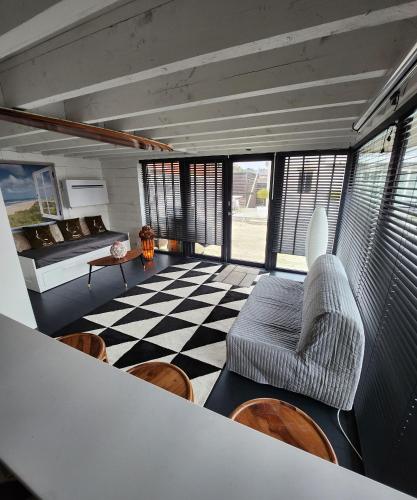 uma sala de estar com um sofá e um piso em xadrez em Tomorrowland loft poolhouse with pool em Willebroek