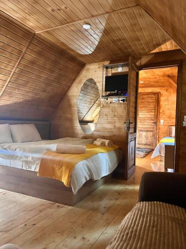a bedroom with a bed in a room with wooden walls at Sunshine House in Kutaisi