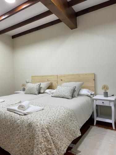 1 dormitorio con 1 cama grande y cabecero de madera en Pensión liebana, en San Vicente de la Barquera