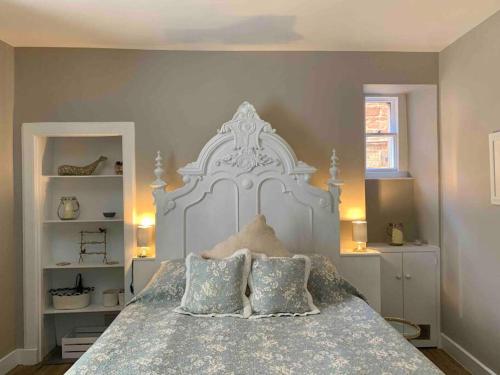 um quarto com uma grande cama branca e 2 almofadas em The Beach Pad North Berwick em North Berwick