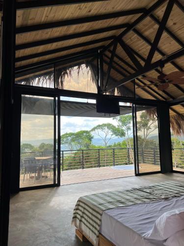 a bedroom with a bed and a large glass window at La Manola Finca Hotel in Doradal