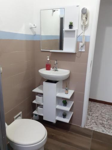een badkamer met een wastafel, een toilet en een spiegel bij 92SOLDAPRAIA Apto preparado para vc e sua familia in Praia Grande