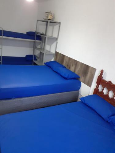 2 camas con almohadas azules en una habitación en 92SOLDAPRAIA Apto preparado para vc e sua familia, en Praia Grande