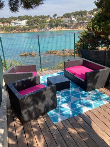 d'une terrasse avec une table et des chaises et une vue sur l'eau. dans l'établissement Les pieds dans l ‘eau, à Sanary-sur-Mer