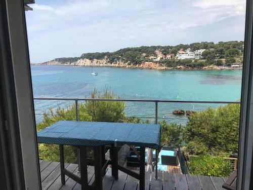 un balcon avec une table et une vue sur l'océan dans l'établissement Les pieds dans l ‘eau, à Sanary-sur-Mer