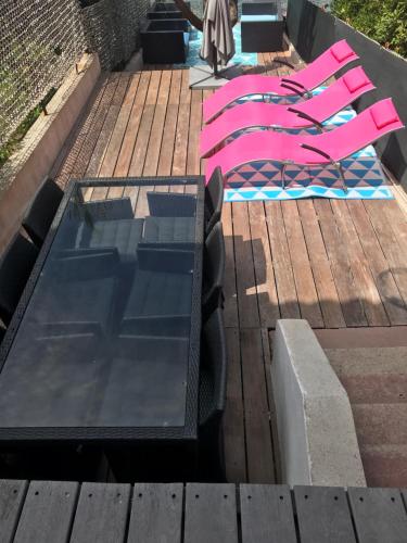 - un groupe de chaises roses et une piscine dans l'établissement Les pieds dans l ‘eau, à Sanary-sur-Mer