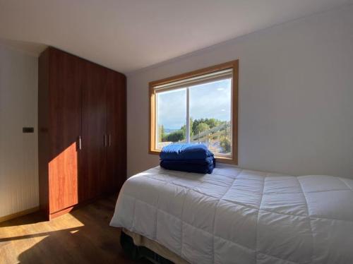 a bedroom with a large bed and a window at Cabaña Altos de Quento 2 , 8 personas equipada in Castro