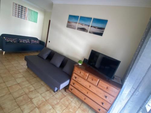 een woonkamer met een bank en een flatscreen-tv bij Cardoso House VPA in Vila Praia de Âncora