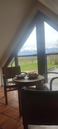 a table and chairs with a view of a field at Bed & Breakfast Na Poljani in Kranj