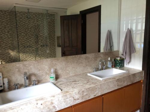 uma casa de banho com 2 lavatórios e um espelho grande em Kronemhouse Pousada em Petrópolis