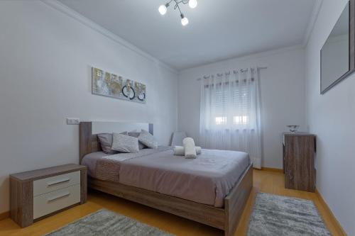 a bedroom with a large bed and a window at Alojamento Santo António in Peniche