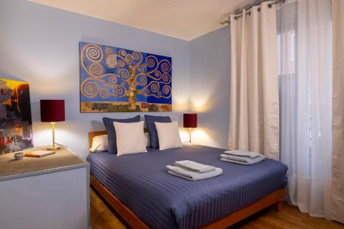 a bedroom with a blue bed with towels on it at Maison Lavaud in Paris