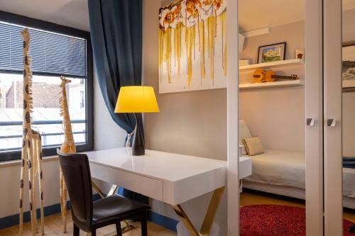 a room with a desk and a bed and a window at Maison Lavaud in Paris