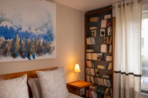 a room with a bed and a book shelf with books at Maison Lavaud in Paris