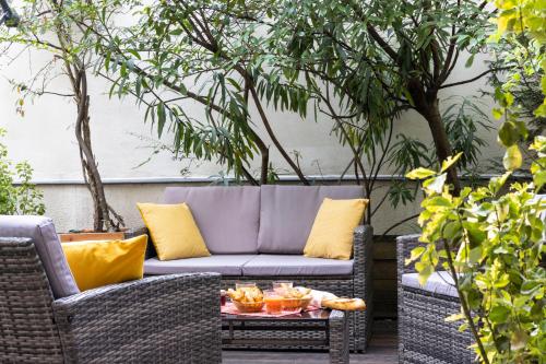 a patio with a couch and a table with food on it at Maison Lavaud in Paris