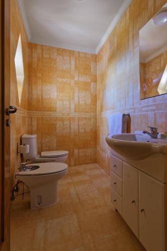 a bathroom with two toilets and a sink at Alojamento Santo António in Peniche