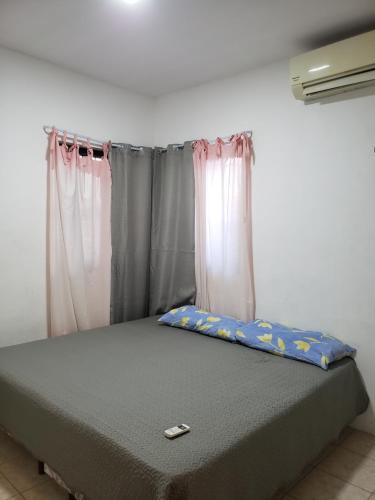 Bett in einem Zimmer mit Vorhängen in der Unterkunft La azul bonita in Chetumal