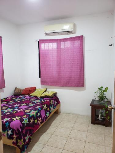 ein Schlafzimmer mit einem Bett mit einem lila Vorhang in der Unterkunft La azul bonita in Chetumal