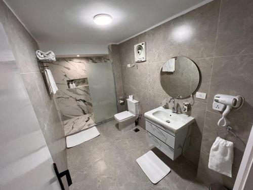 a bathroom with a sink toilet and a mirror at New cairo apartment in front of Garden 8 Mall in Cairo