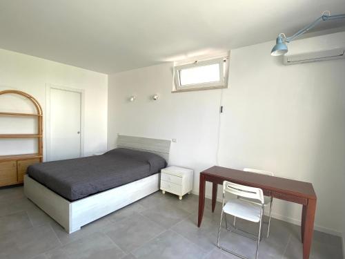 een slaapkamer met een bed, een bureau en een tafel bij La Stella Marinella in Santa Marinella