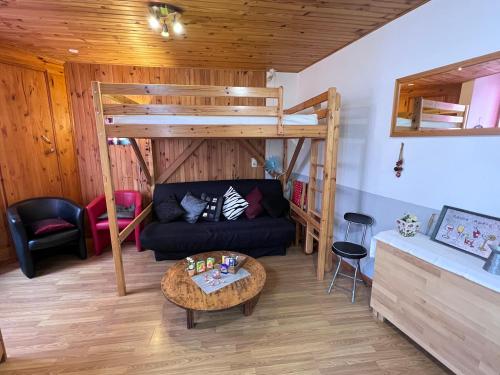 ein Wohnzimmer mit einem Sofa und einem Hochbett in der Unterkunft L'Astazou "PRÊT gracieux du matériel de SKI" au studio in Luz-Saint-Sauveur